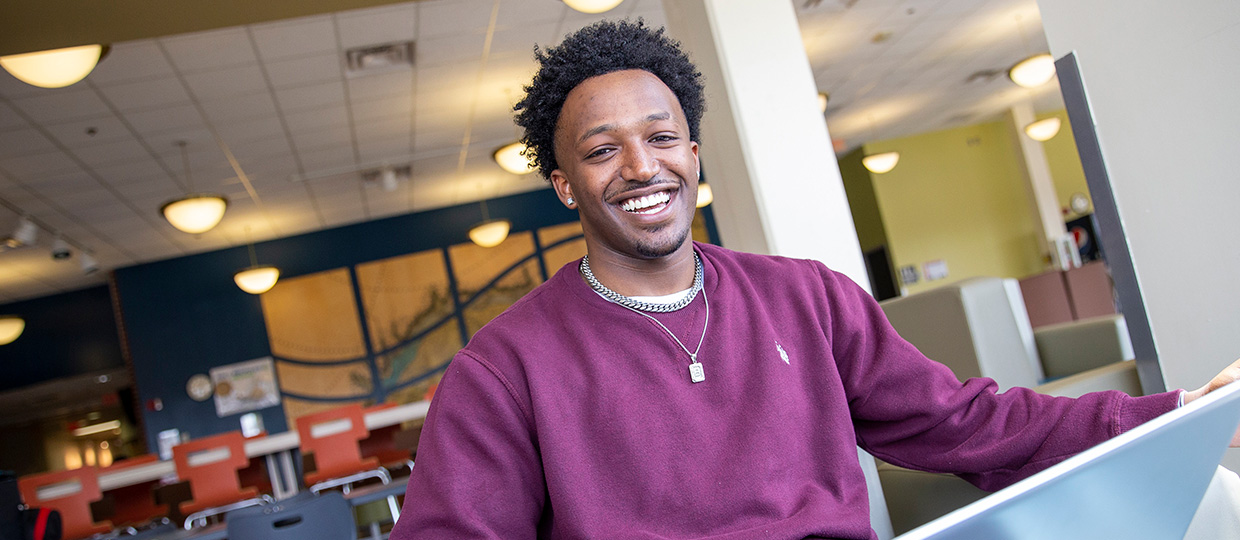 Beteab D. Tefera  ’22, Computer Science Transfer Pathway smiling at camera in hall