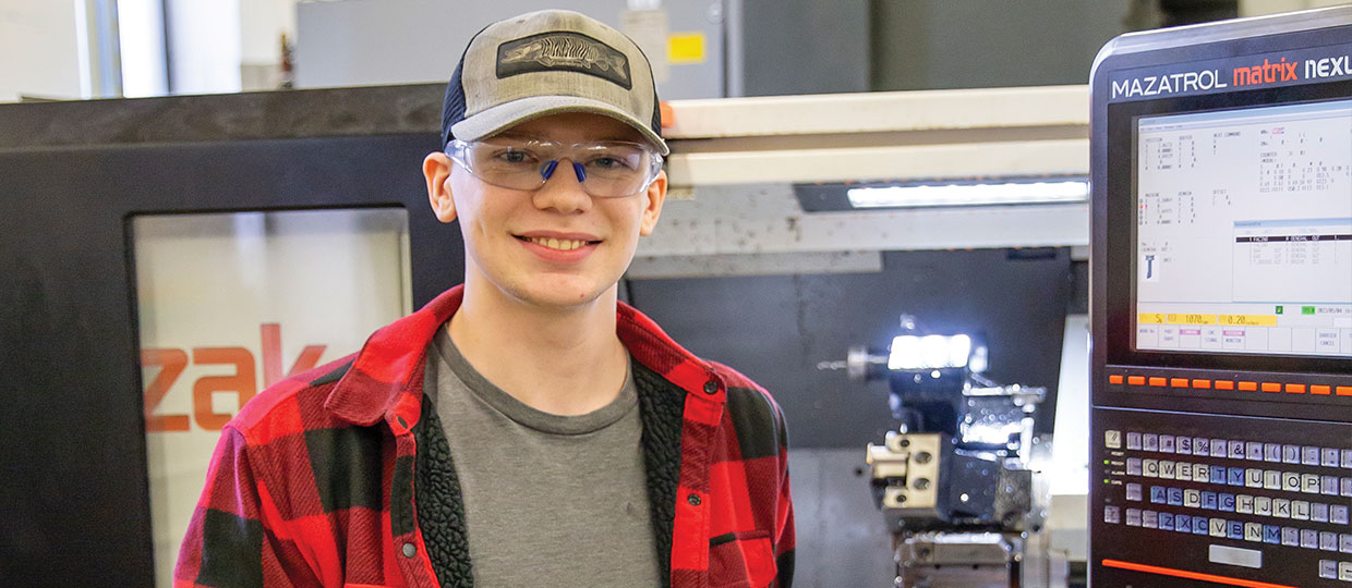 Hunter Ogden, AAS CNC Design and  Manufacturing Technology student using machine